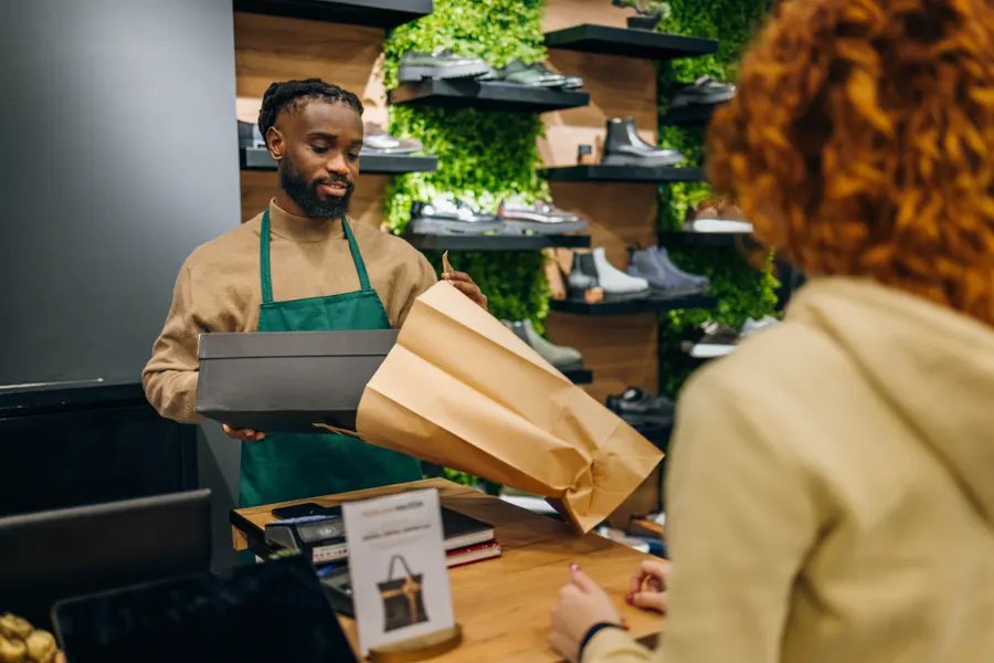 A shop assistant bagging a pair of shoes