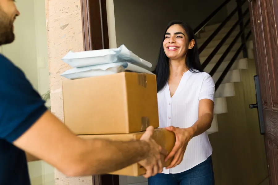 A customer receiving a stack of parcels at the door