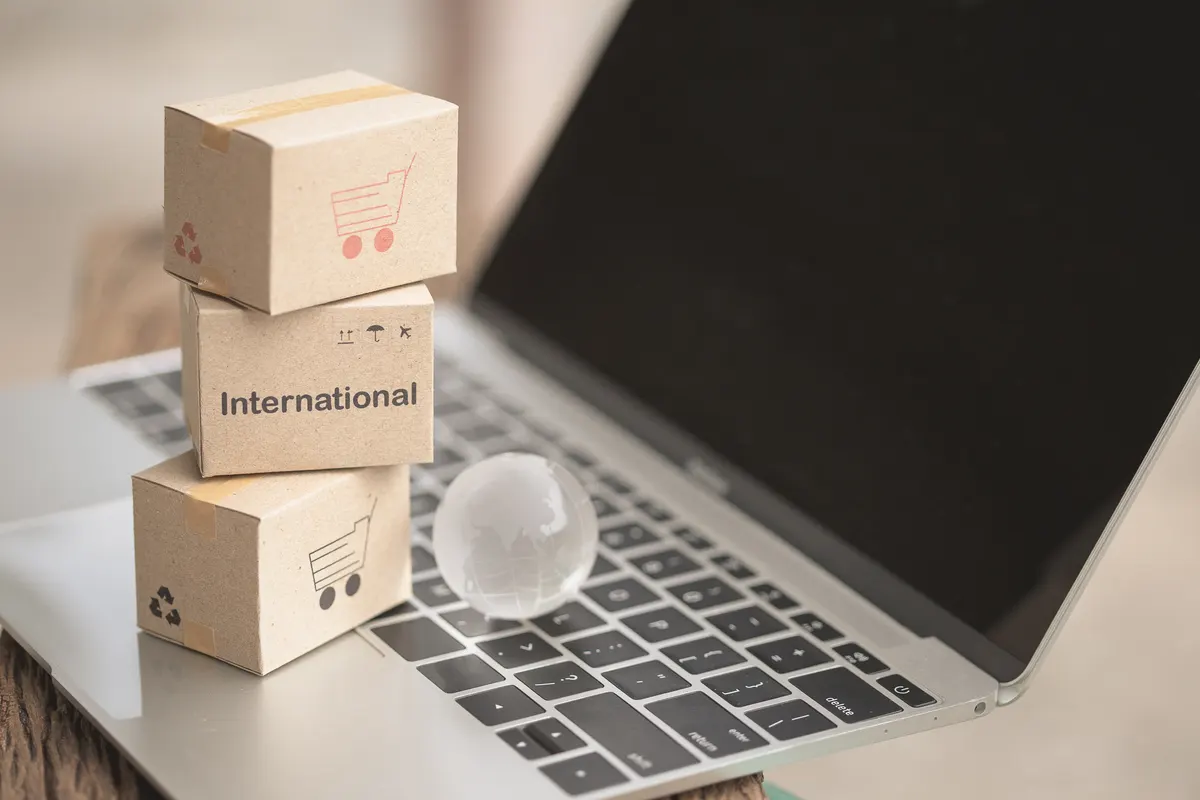 International ecommerce expansion: idea International shipping and service / e-commerce concept. Stack boxes on tablet computer for Customer can buy from electronic internet and the messenger from delivery.