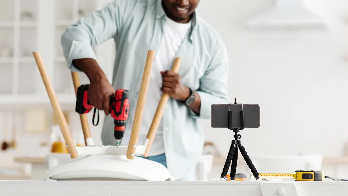 Meta ads for ecommerce: handyman blogger shooting video instructions for assembling furniture at home with own hands, using electric drill, crop.