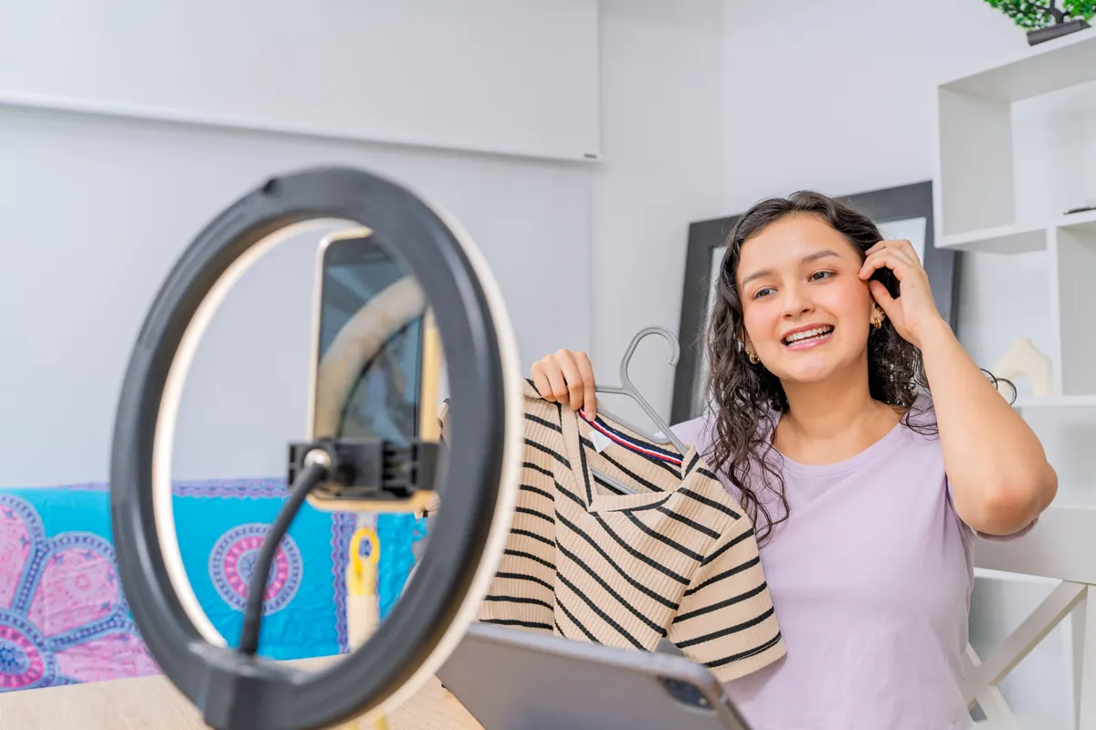 Tiktok ads for ecommerce: young female influencer recording fashion haul for social media.