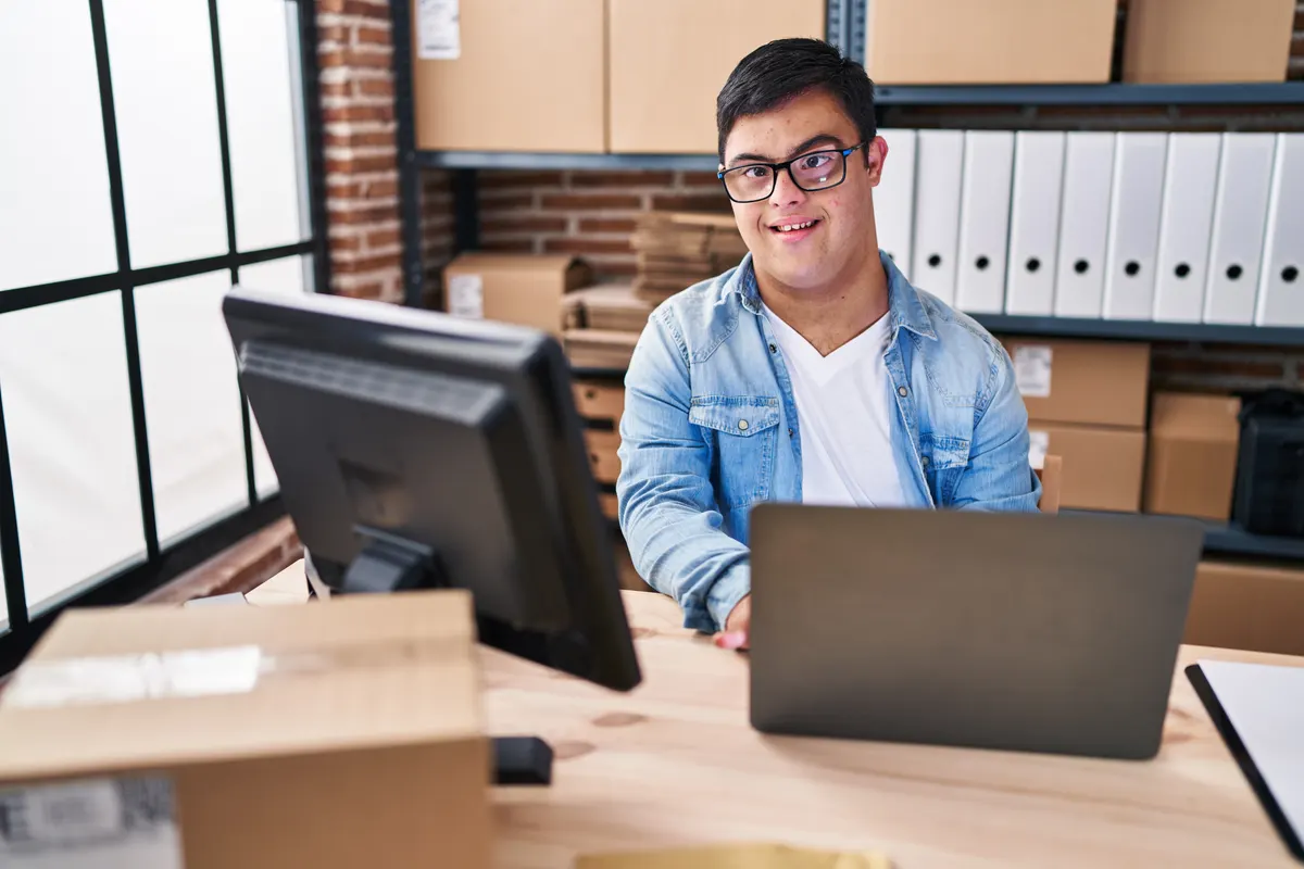 Woocommerce SEO: down syndrome man ecommerce business worker using laptop working at office.
