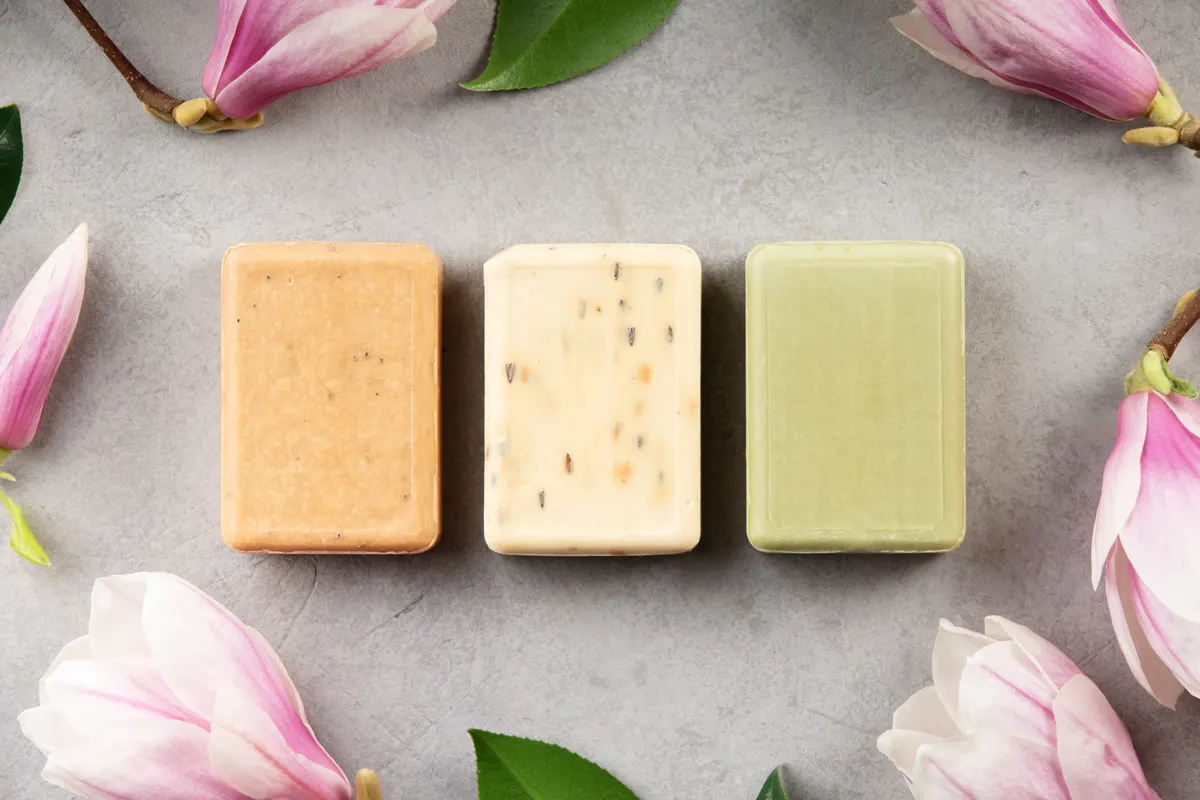 Health & wellness ecommerce marketing agency: natural Handmade Soap Bars with Flowers on Gray Background.