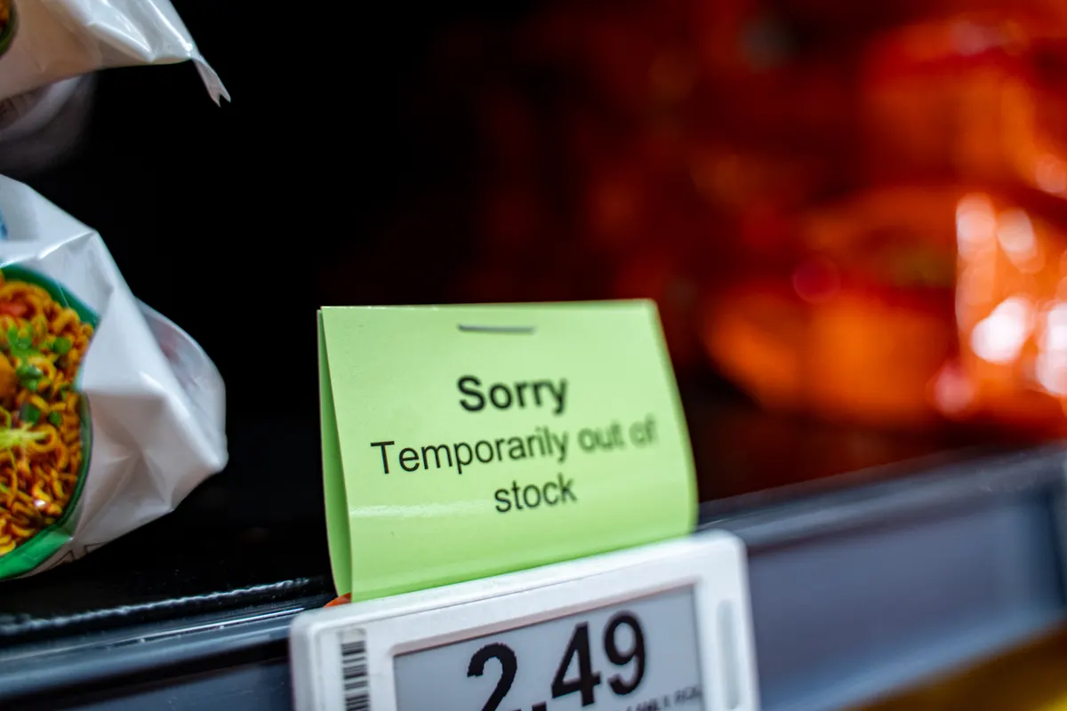 How to handle out-of-stock pages without losing rankings: view of Sorry Temporarily Out of Stock sign on market shelf.