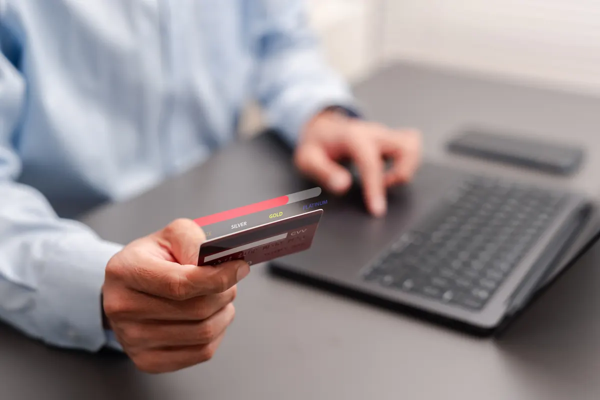 Loyalty programs: loyalty program and membership tier concept. Businessman holding credit card with VIP upgrade progress bar.