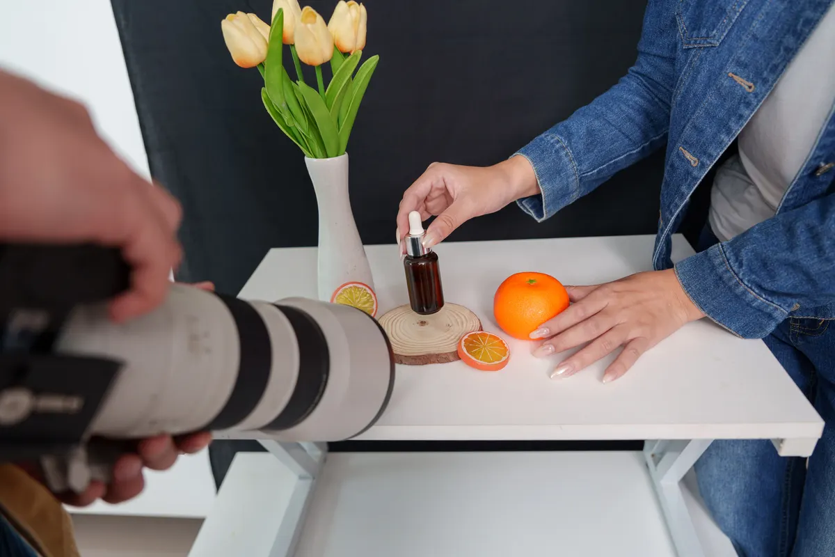 Subscription churn: point of view shot of photographer taking photo of cosmetic serum bottle setup on table.