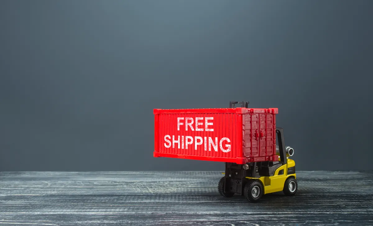 The real cost of a free shipping threshold: forklift loaded with free shipping container. World trade, logistics. Attractiveness of purchasing a product, a marketing move. Special delivery conditions for buyers, competition in foreign markets.