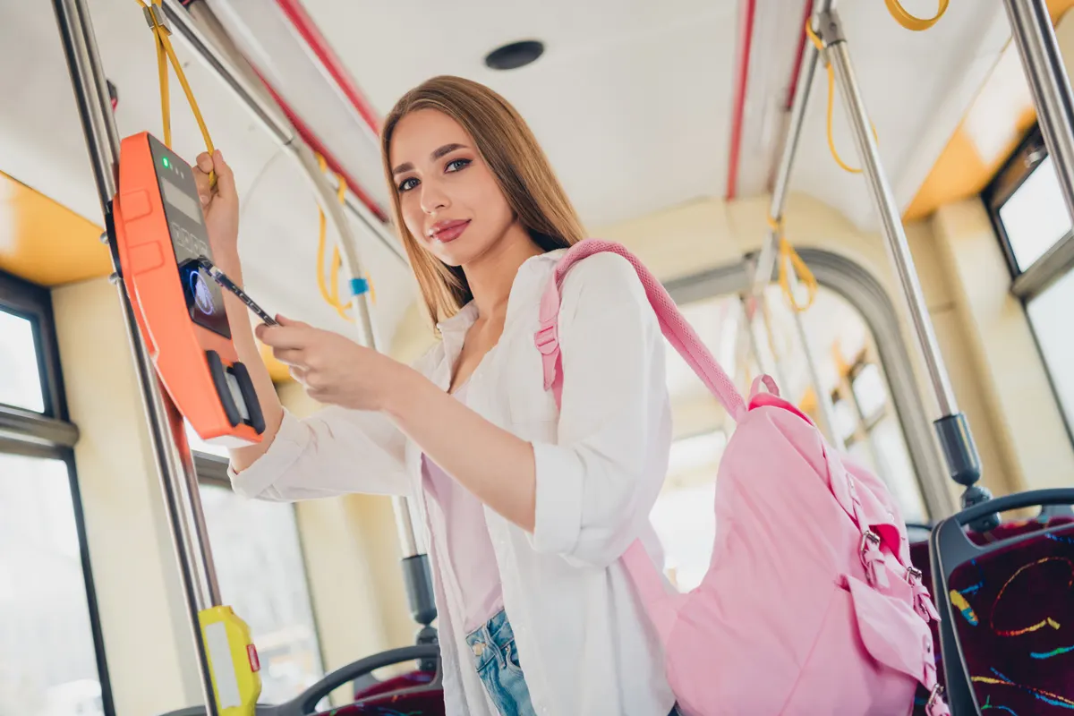 Wallets and express checkout: photo of young girl backpack hold smart phone pay buy ticket terminal travel commute public transport bus.
