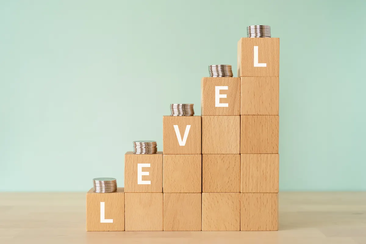 What a 1% conversion lift is worth at every revenue level: wooden blocks with "LEVEL" text of concept and coins.