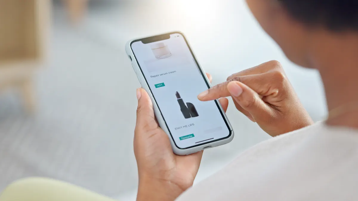 What Google's shop tab means for small brands: online shopping, phone and hand scroll on makeup website for sale and deal on skincare. Person, beauty and cosmetics on mobile app for lipstick product on social media store with digital catalog.