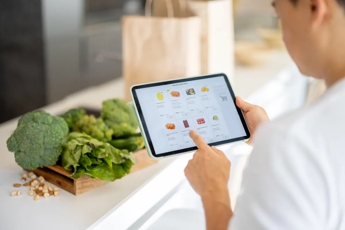 Why collection pages outrank product pages: man watch groceries in online store on gadget.