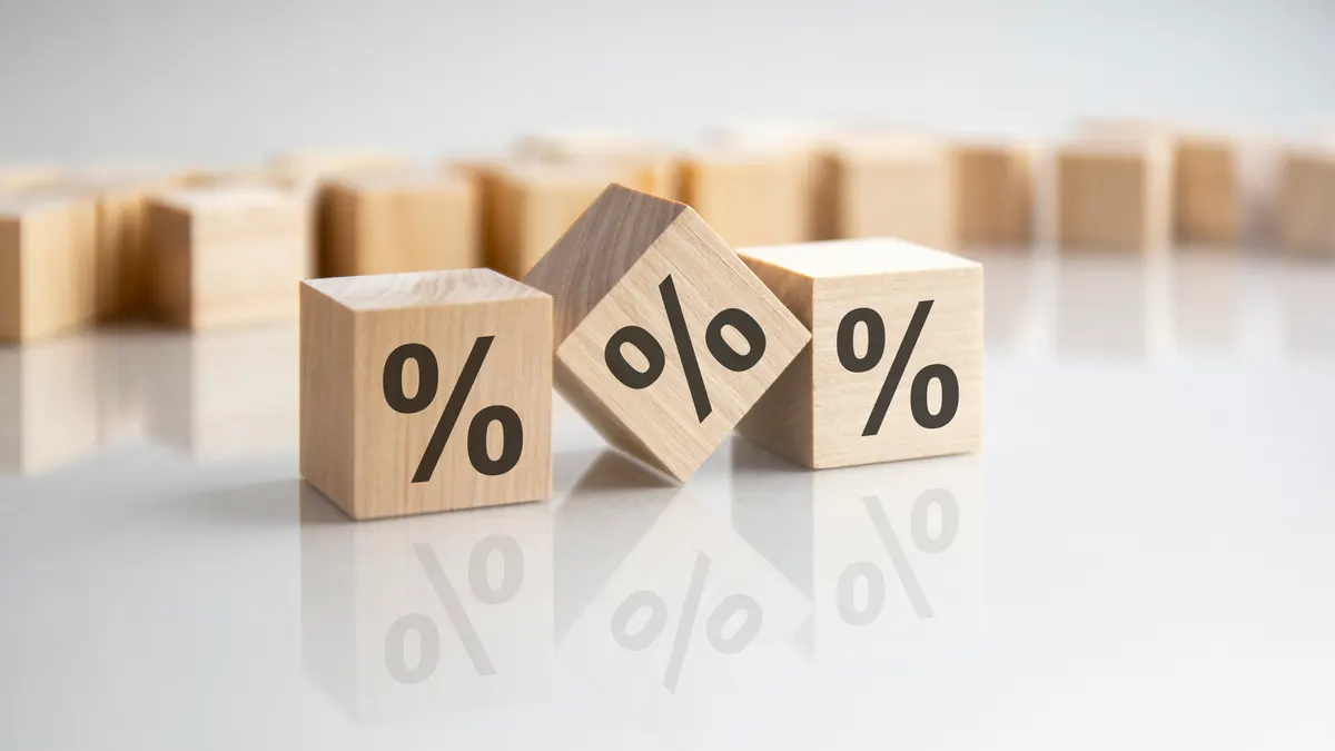 Why we never take a percentage of ad spend: close up image a wooden cube with percent signs on wooden cubes. white background.