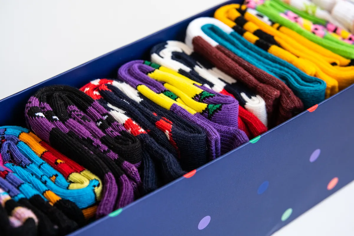 Sock & hosiery marketing agency: several colorful cotton socks rolls in a box.