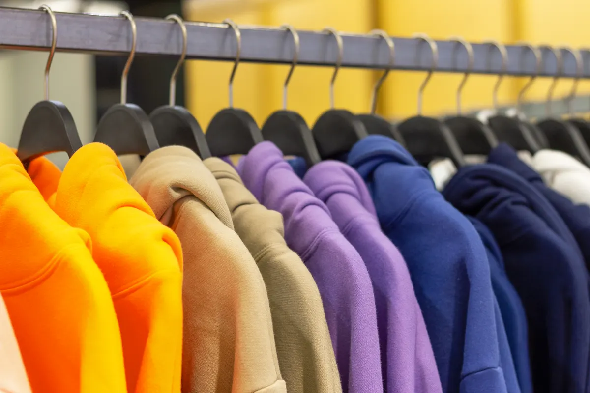 Streetwear marketing agency: colorful hoodies on hangers in a sports store close-up.