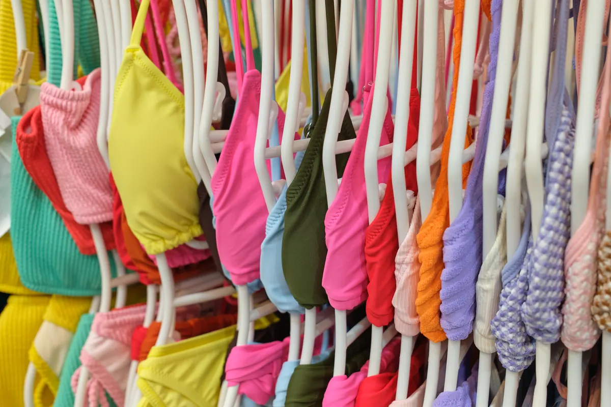 Swimwear marketing agency: close Up of Colorful Swimwear on Retail Rack. Detailed view of vibrant swimsuits displayed in a fashion boutique.