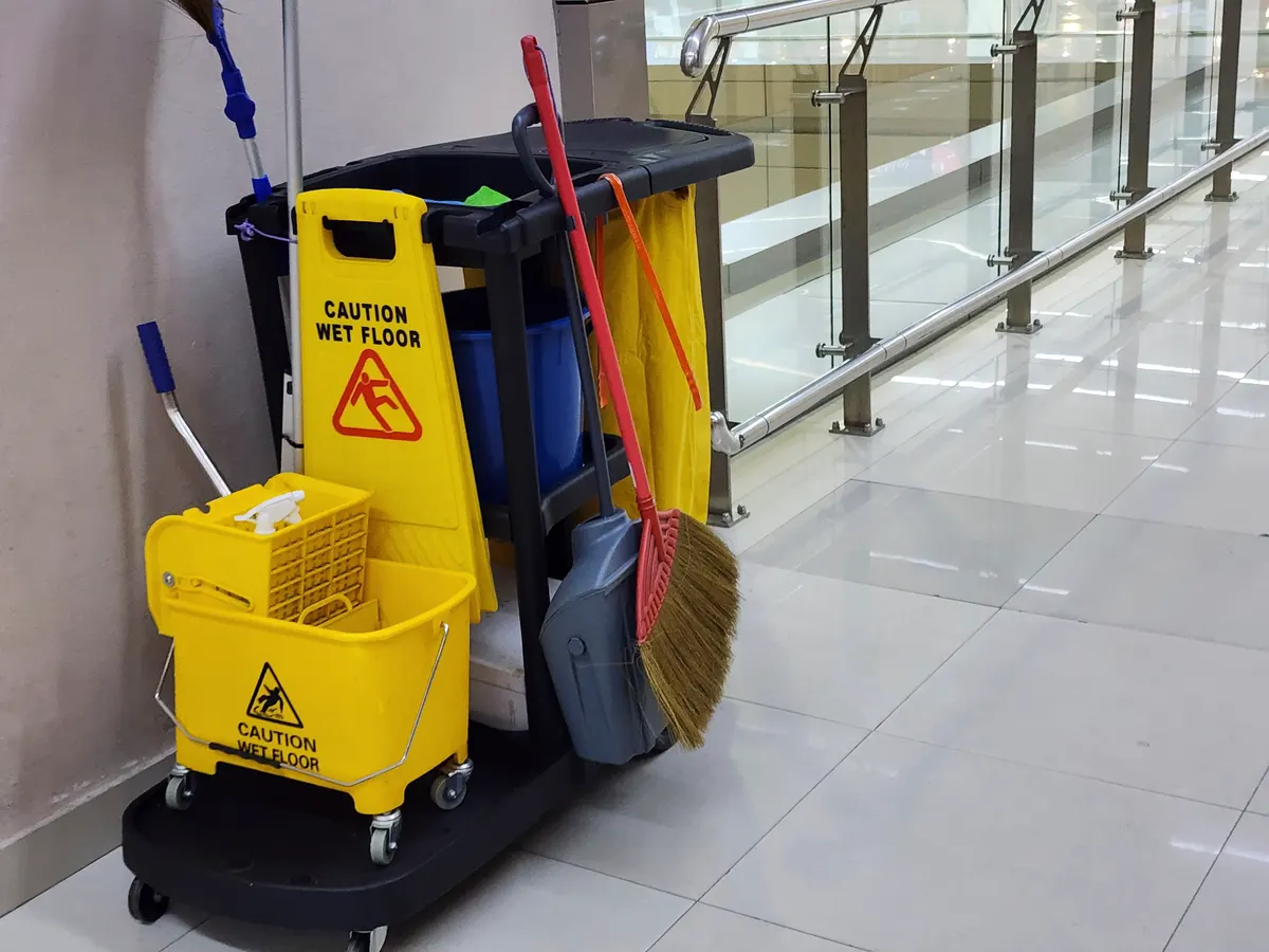 Janitorial supply marketing agency: janitorial and mop bucket on cleaning in process with copy space indoor.