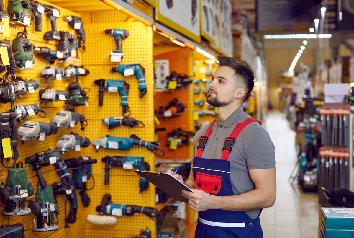 Tool & hardware marketing agency: salesman who works at a DIY store or shopping mall is checking construction tools.