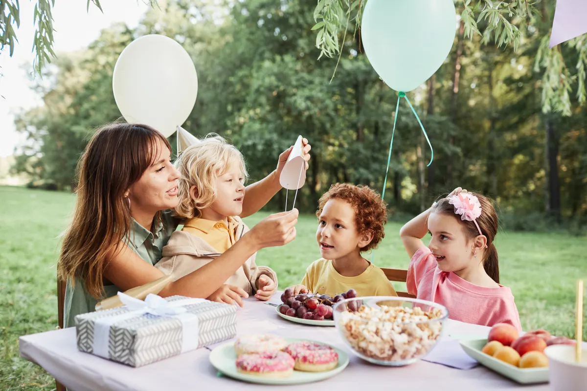 Kids' party supply marketing agency: young Woman with Kids at Birthday Party.