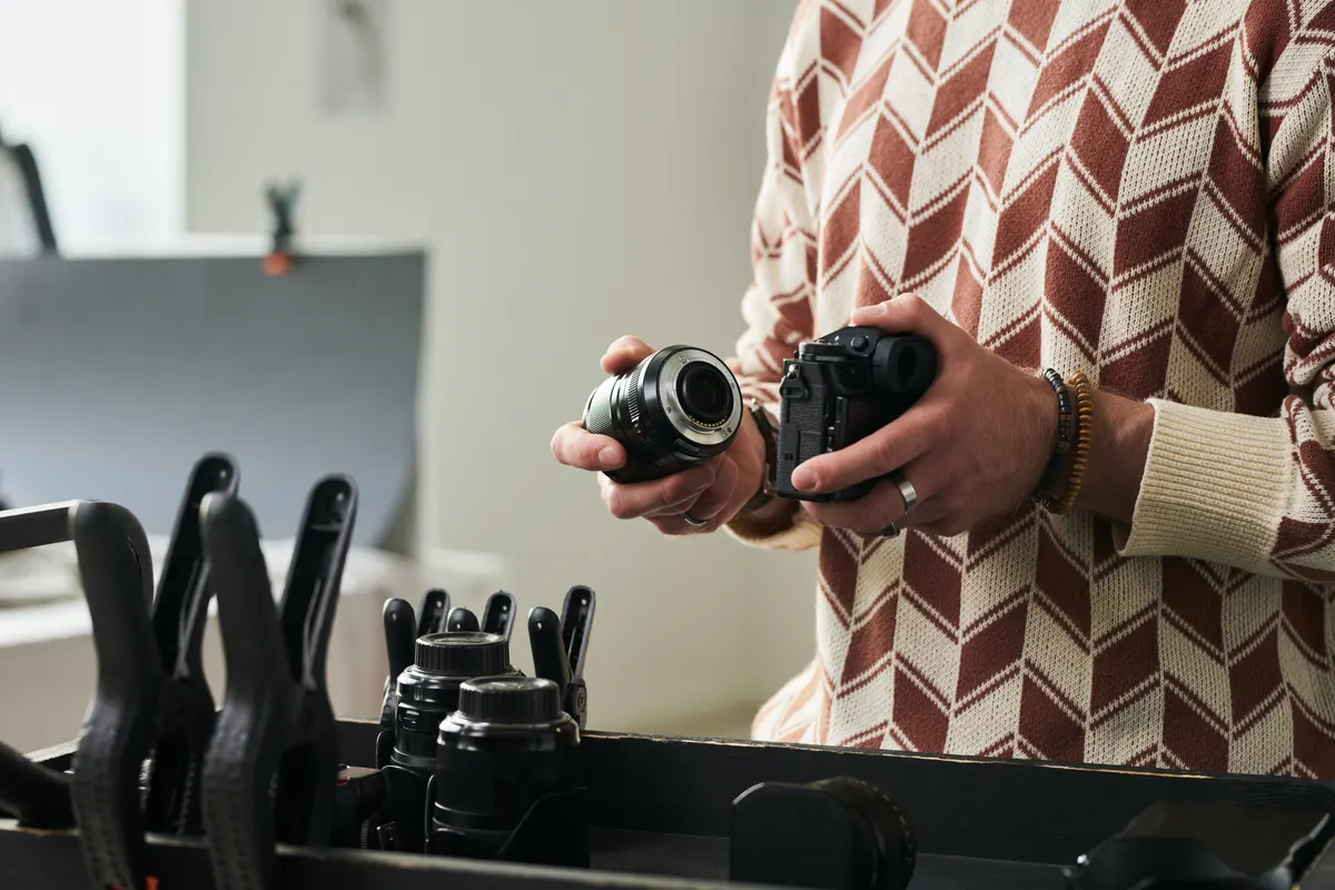 Camera gear marketing agency: man Assembling Camera Lens in Professional Studio.