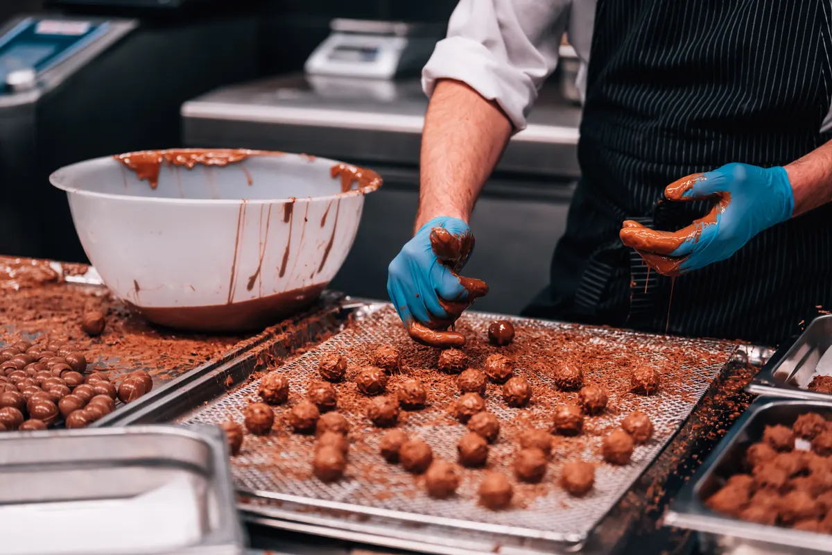 Chocolate & confectionery marketing agency: chocolatier crafting truffles in a kitchen.