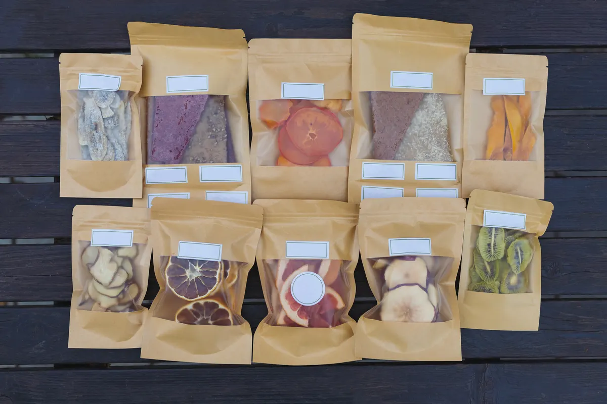 Healthy snack marketing agency: dried fruits packaged in eco-friendly paper bags. Healthy desserts concept.