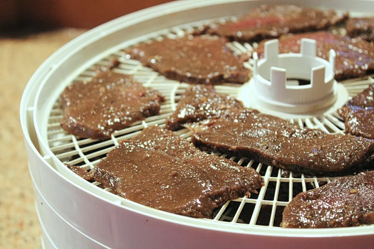 Jerky & meat snack marketing agency: meat slices laid out on a dehydrator to be made into deer jerky.
