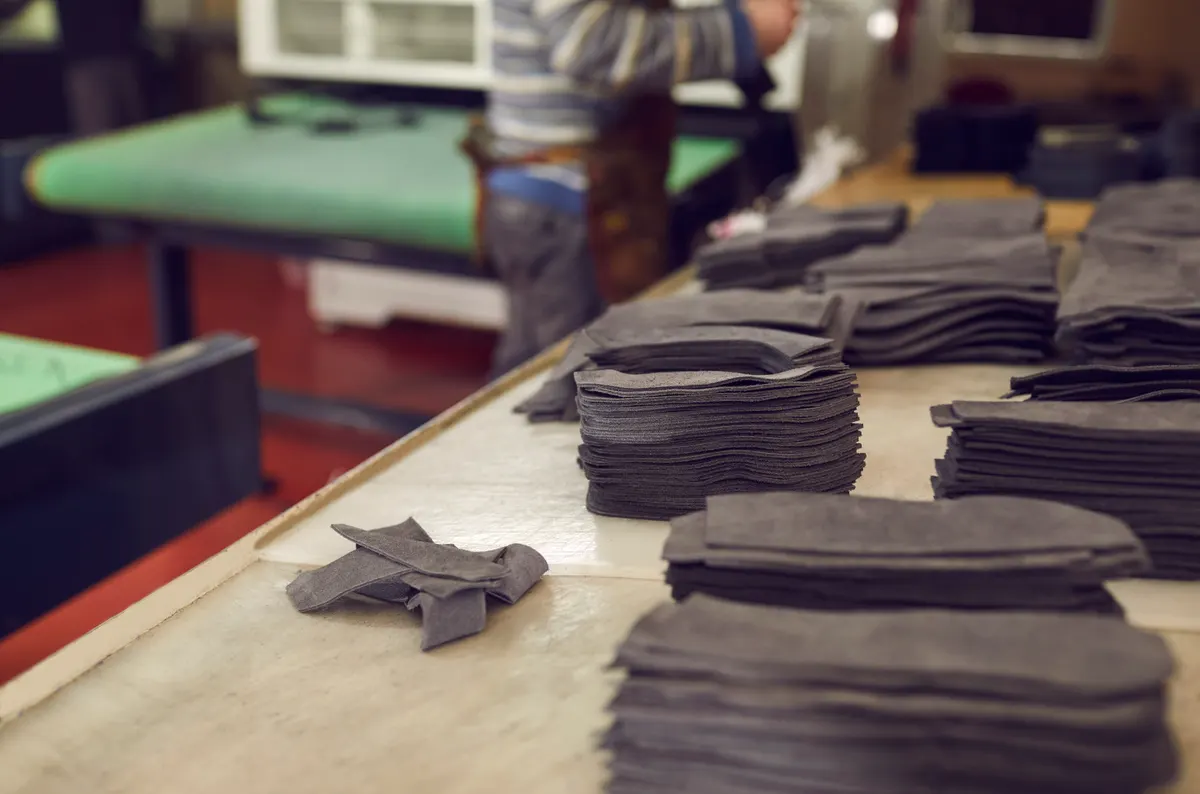 Vegan footwear marketing agency: lots of details for future footwear lying on table in workshop at shoe making factory.