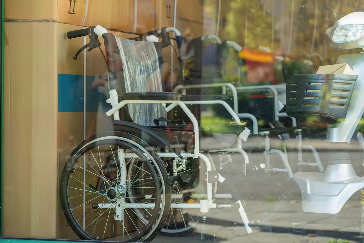 Mobility aid marketing agency: wheelchair in Storefront. Wheelchairs displayed in shop window among packed medical equipment and mobility aids. Concept of accessibility, healthcare supply, elderly care.
