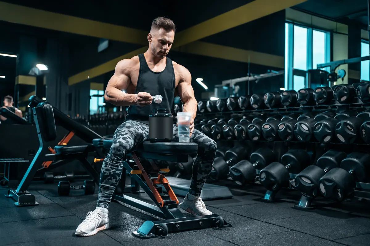 Sports nutrition marketing agency: athlete man preparing protein cocktail or use sport nutrition supplement in gym.