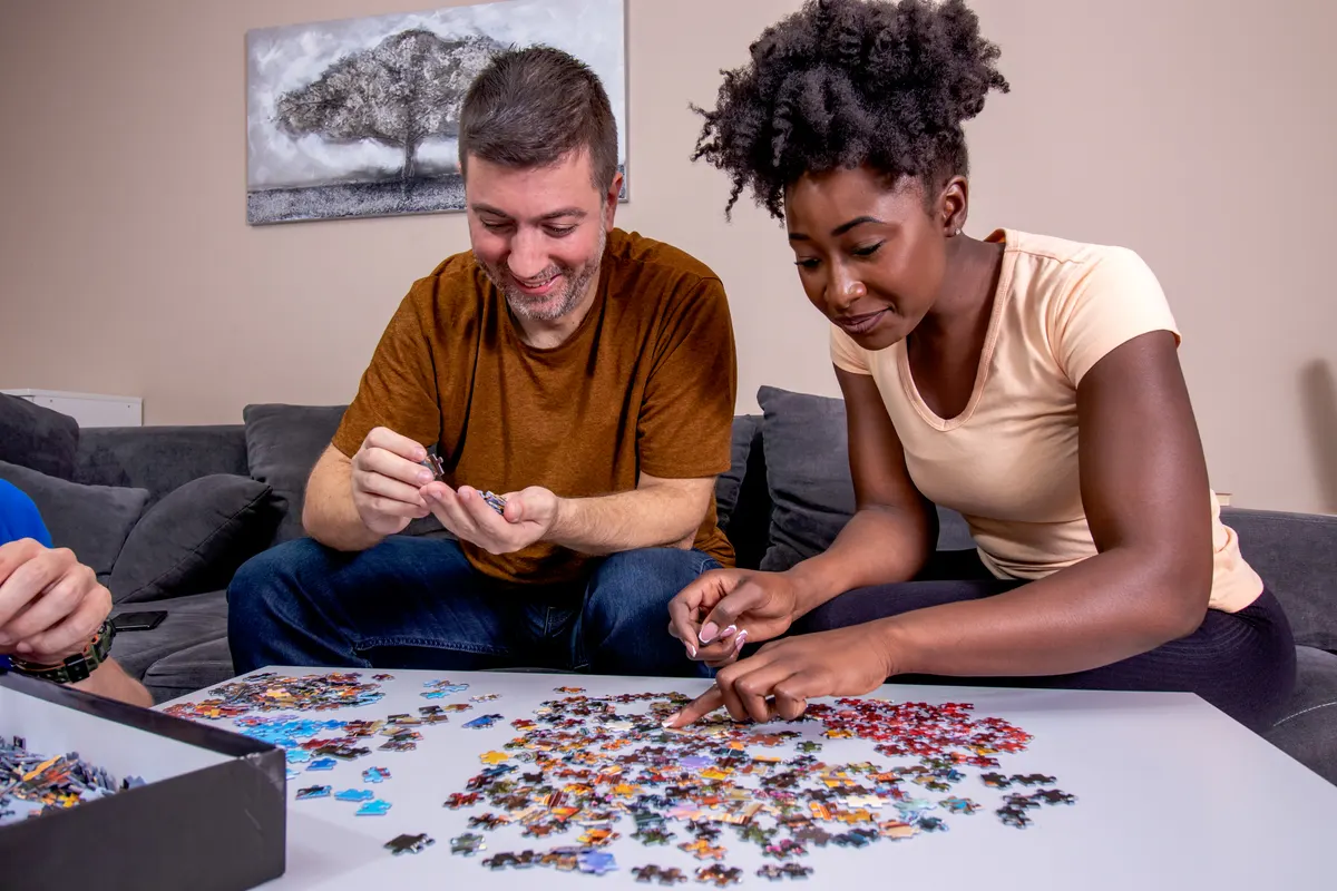Puzzle marketing agency: a couple playing jigsaw puzzle at home.