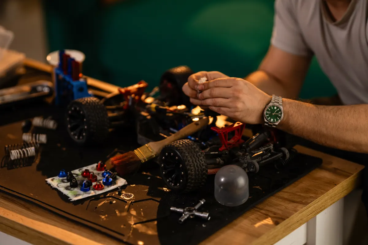 RC vehicle marketing agency: man repairing radio-controlled car, hobby and engineering.