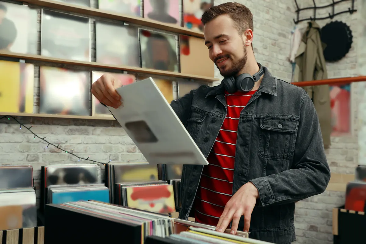 Vinyl record marketing agency: young man with vinyl record in store.