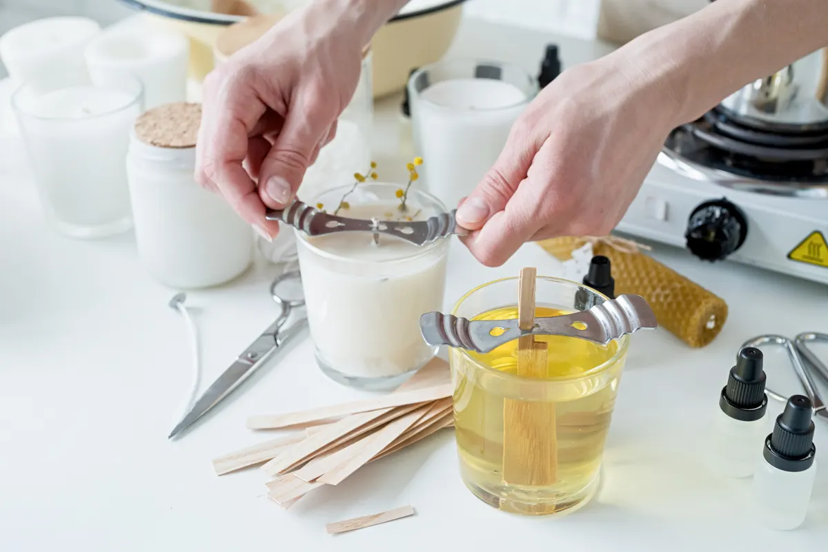 Candle & home fragrance marketing agency: closeup of woman setting the wooden wick into handmade candle.