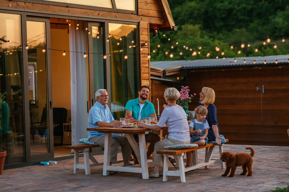 Outdoor furniture marketing agency: family dinner around dining table in the garden.