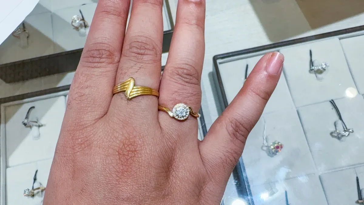 Engagement ring marketing agency: female customer testing engagement and fashion gold rings at indoor.