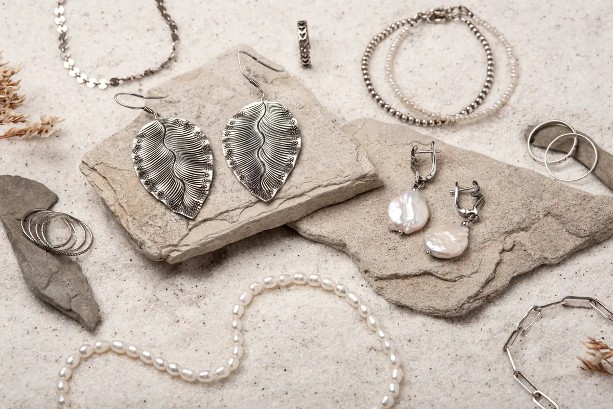 Fashion jewelry marketing agency: beautiful Silver and Pearl Jewelry on white sand.