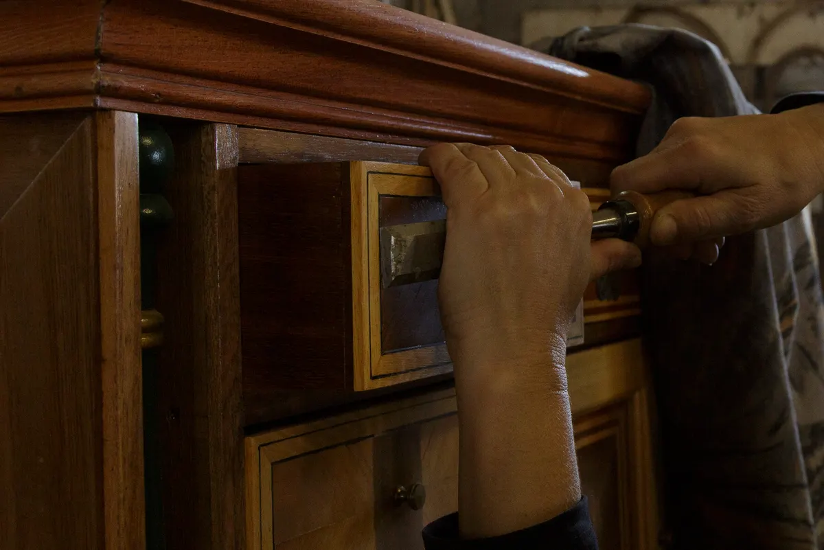 Antique dealer marketing agency: carefully Restoring Old Wooden Drawer With Textured Patina And Precise Craftsmanship.