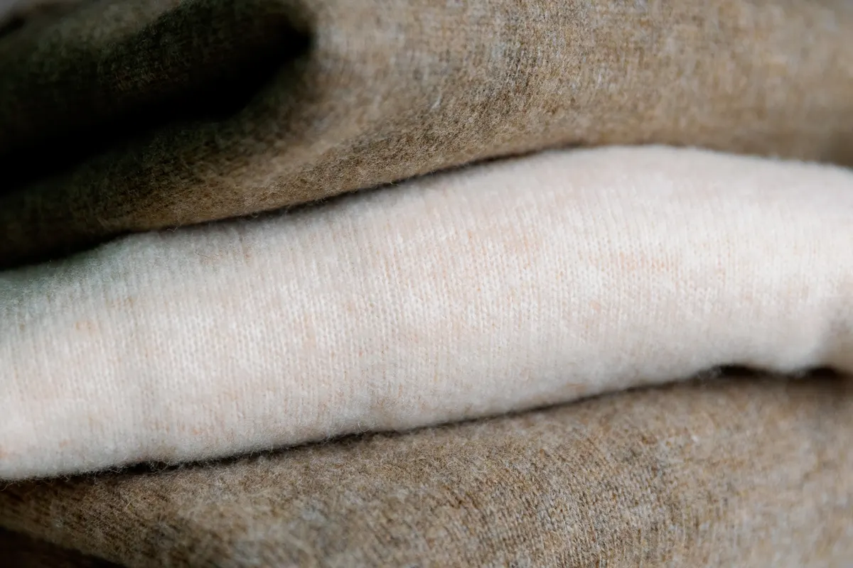 Cashmere marketing agency: three pieces of stacked cashmere sweaters.
