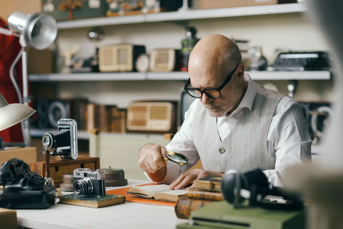 Rare book dealer marketing agency: business owner checking vintage items in his shop.