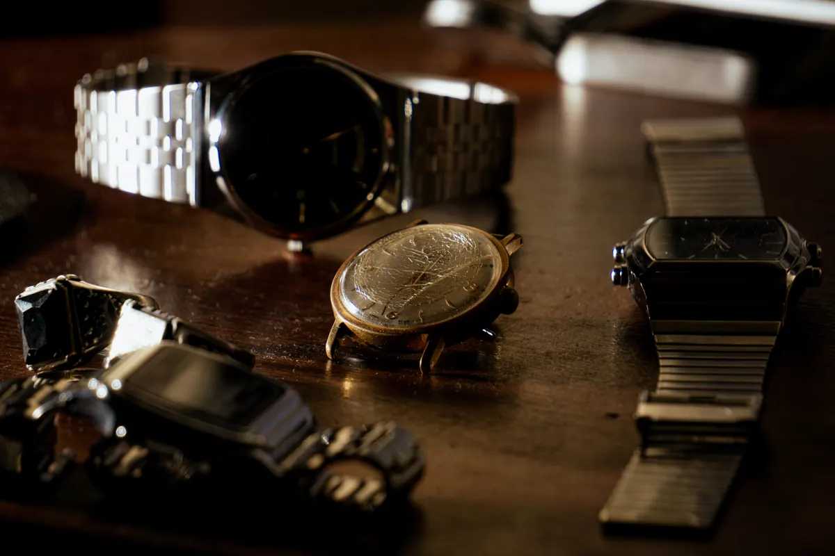 Vintage watch dealer marketing agency: close-up of a collection of wristwatches on a dark wooden surface.