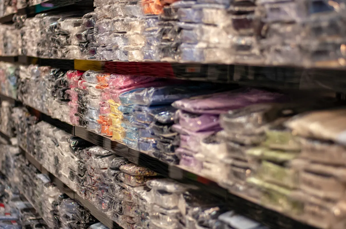 Wholesale marketplace brand marketing agency: piles of shirts on a shelf in a store. Market and wholesale.