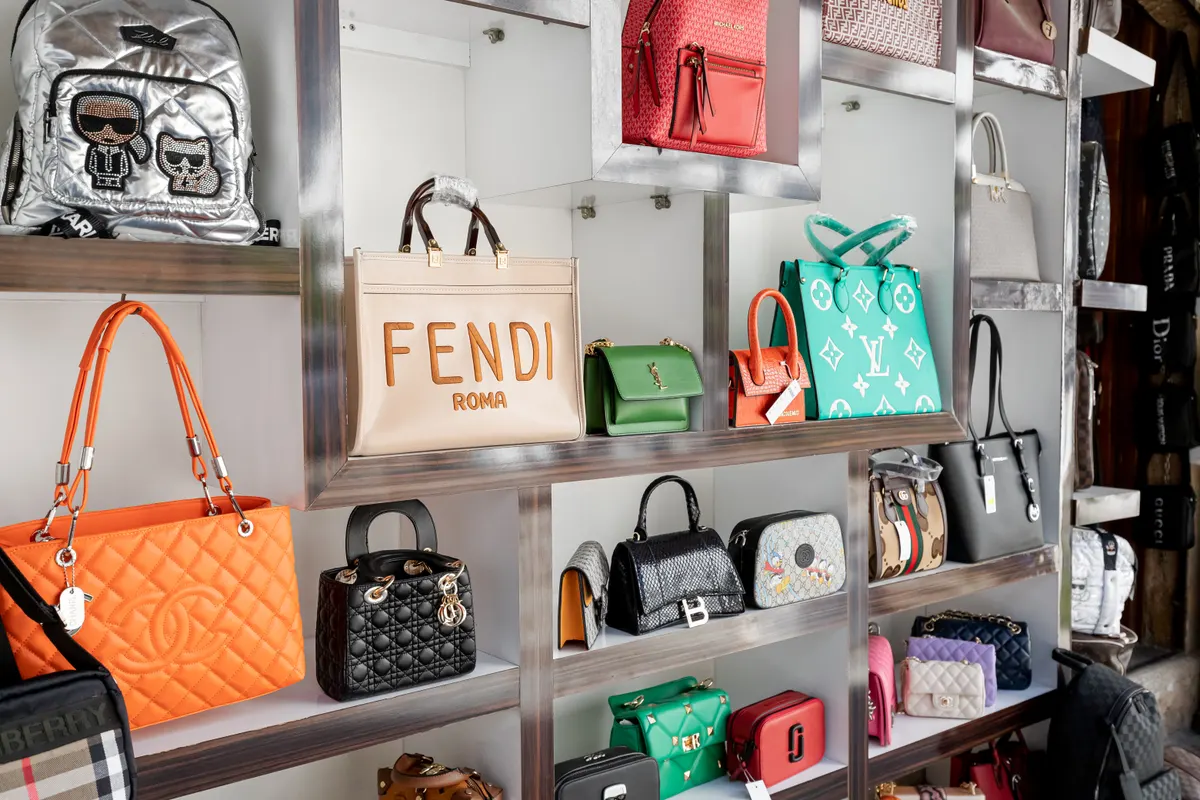 Mid-market ecommerce brand marketing agency: counterfeit fakes of bags of famous world brands of fashion accessories for sale at market - Gucci, Yves Saint Laurent, Chanel and others.