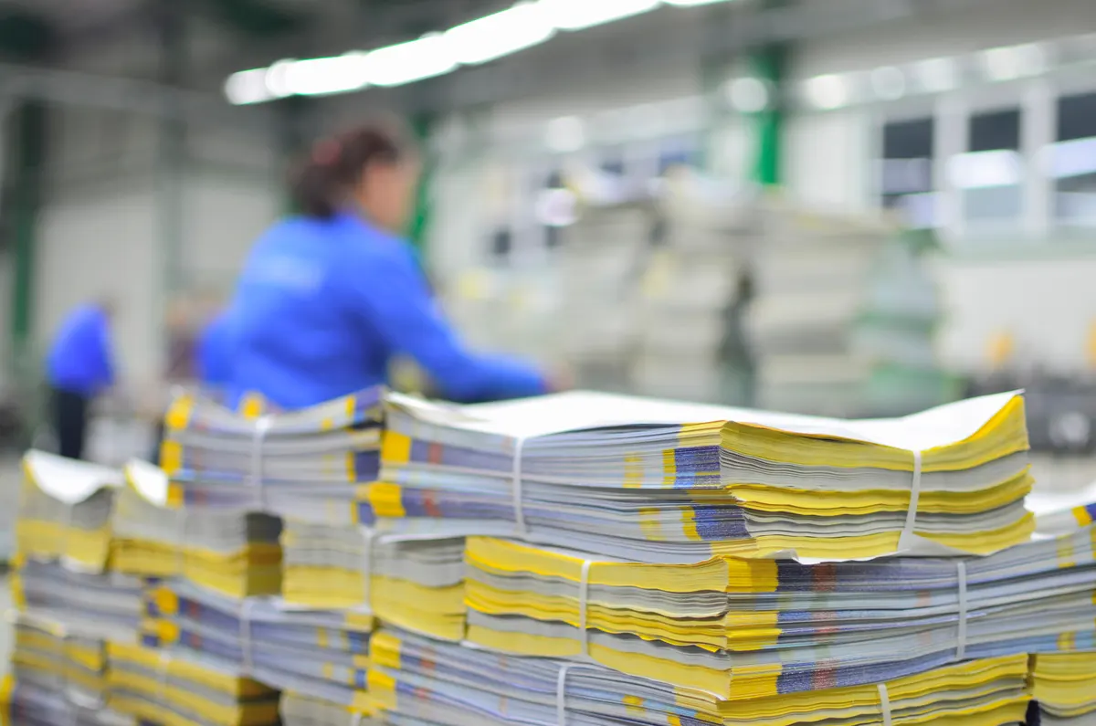 Custom printing marketing agency: stuck of newspaper magazine in print production process.