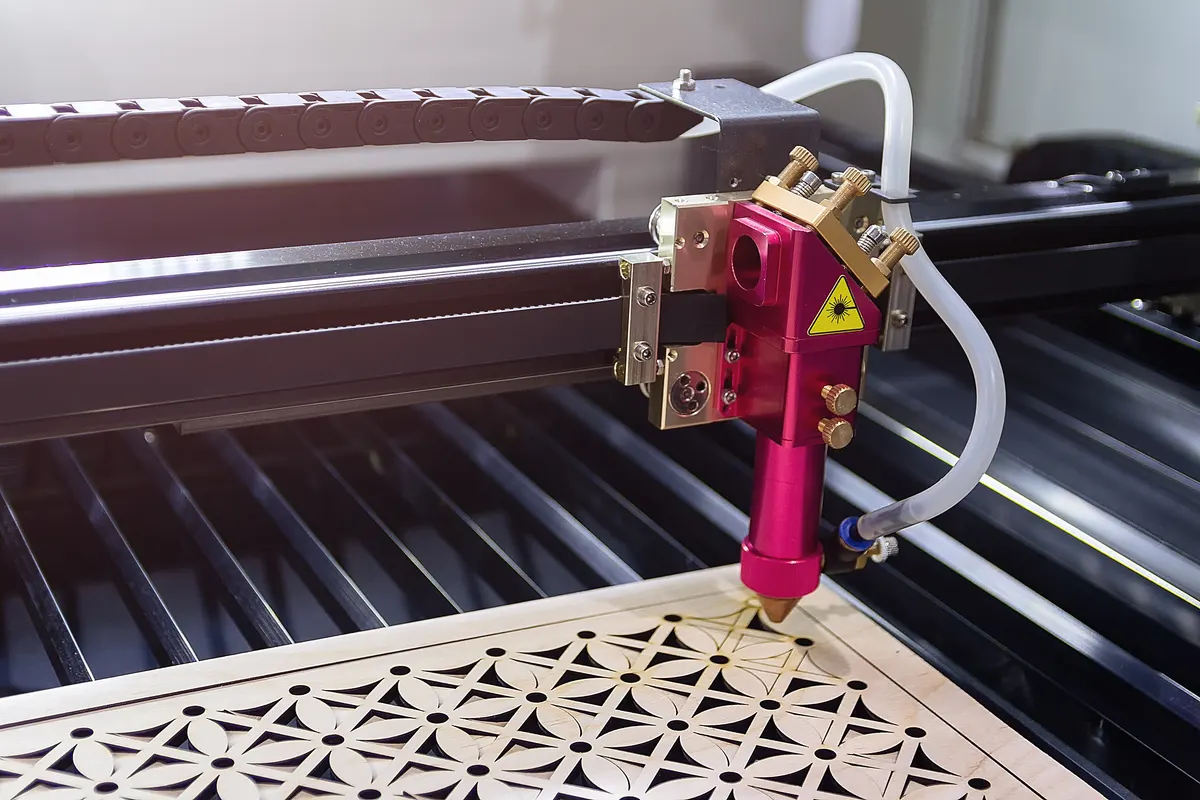 Engraved gift marketing agency: laser engraving machine carves a design on a wooden surface.