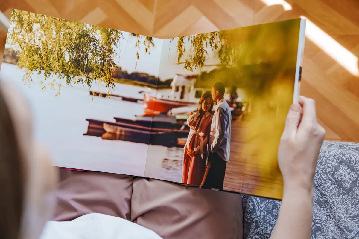 Photo book & print marketing agency: woman is holding and flipping through a photo book with a pregnancy photo shoot.