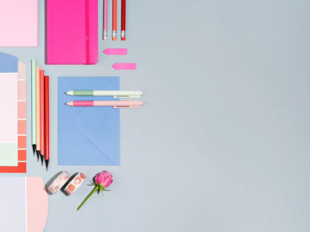 Stationery & planner marketing agency: top view of designers workplace with colour swatch and office supplies. Desk of artist or creative occupied freelance girl. Mock up of planner, to do list, sketchbook. Work from home concept.