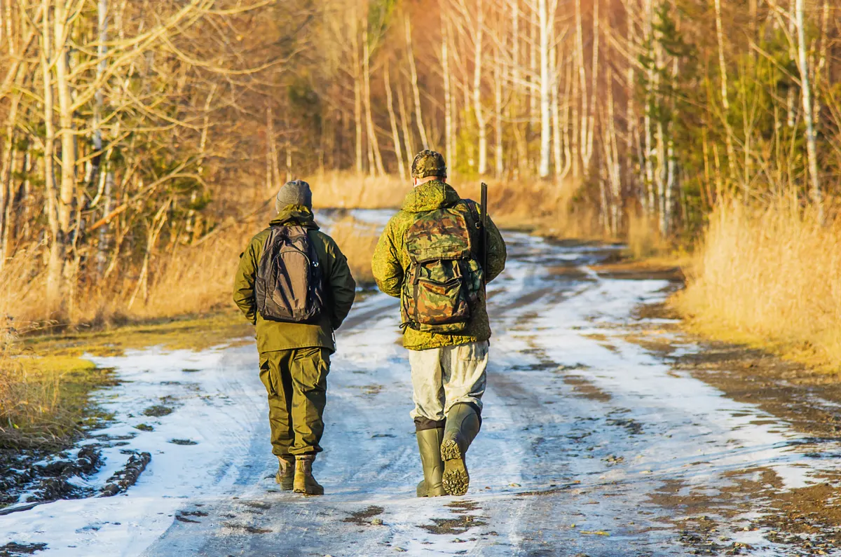 Hunting gear marketing agency: two hunters in the forest in late autumn.