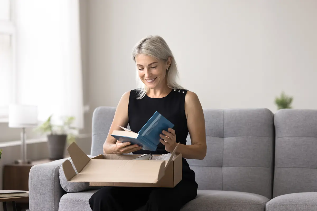 Book subscription marketing agency: smiling mature woman get parcel with ordered books.