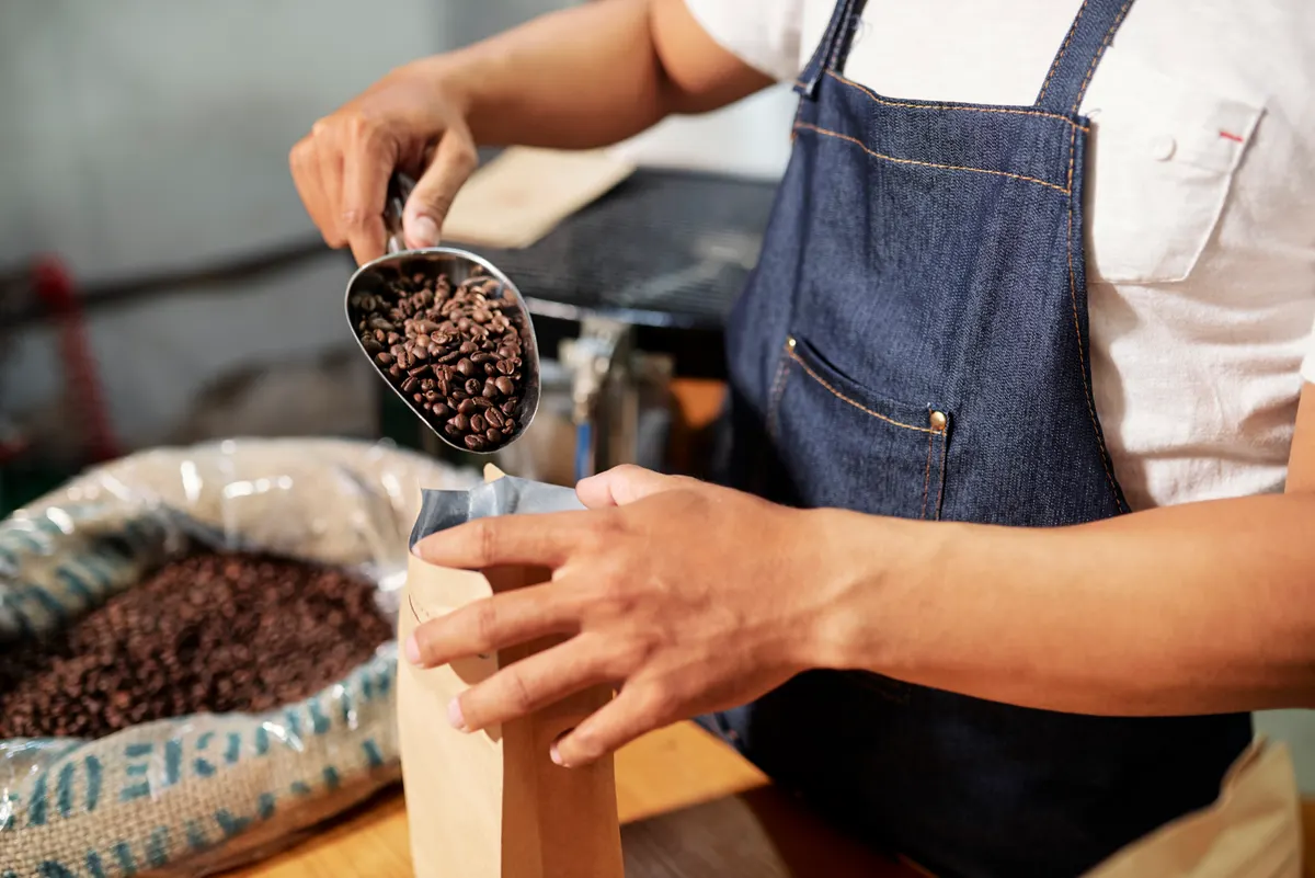 Coffee subscription marketing agency: packing coffee beans in bag.