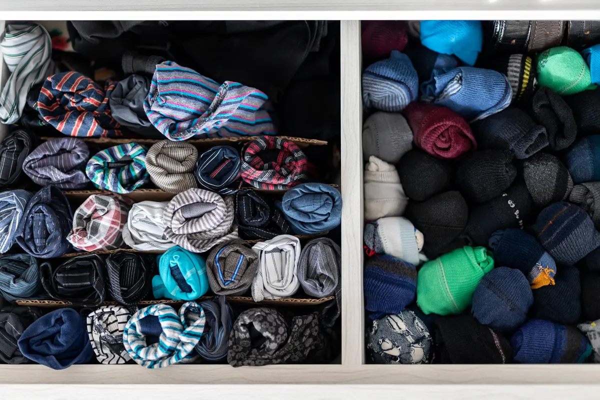 Sock & underwear subscription marketing agency: home drawer box with organized folded underwear lingerie KonMari marie kondo vertical storage method. Sorted many different undergarments pants and socks at bedroom dresser.